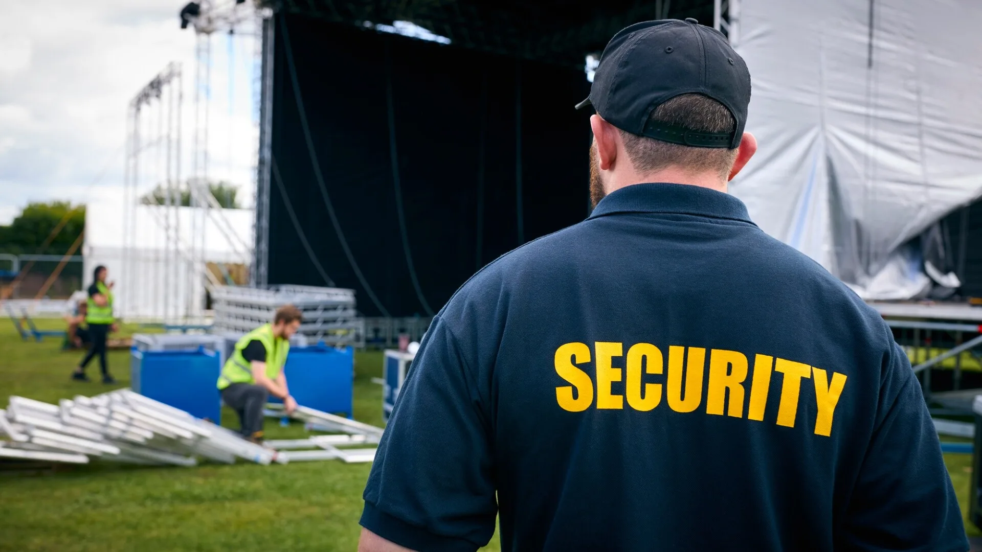 back view of guard in uniform with security lettering standing on city street